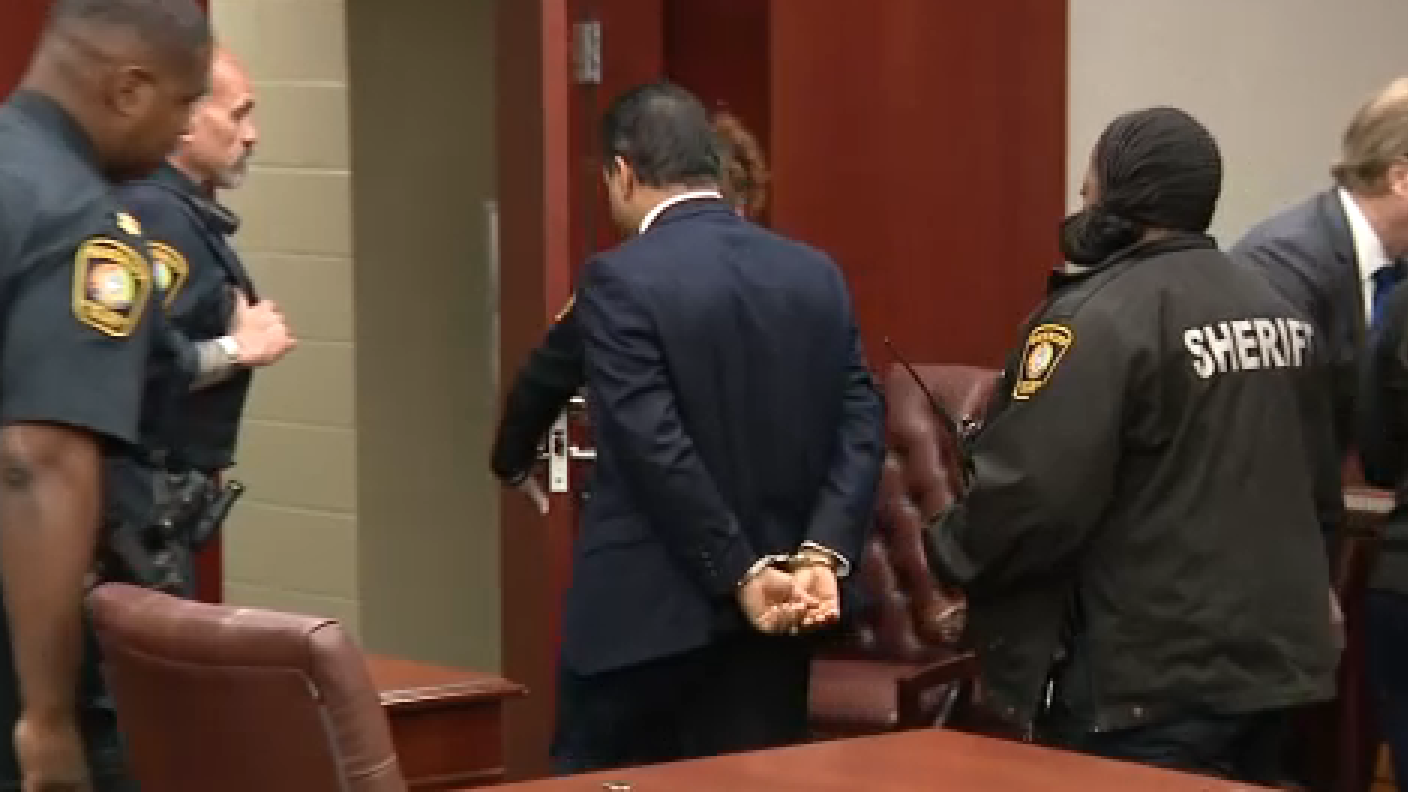 KP George esposado siendo llevado fuera del tribunal tras el veredicto de culpabilidad