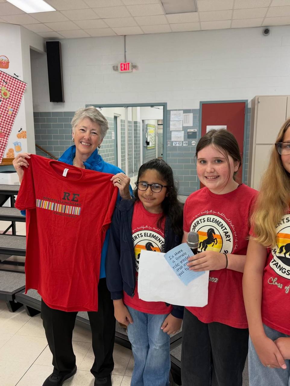 Annise Parker con estudiantes sosteniendo camiseta de Roberts Elementary
