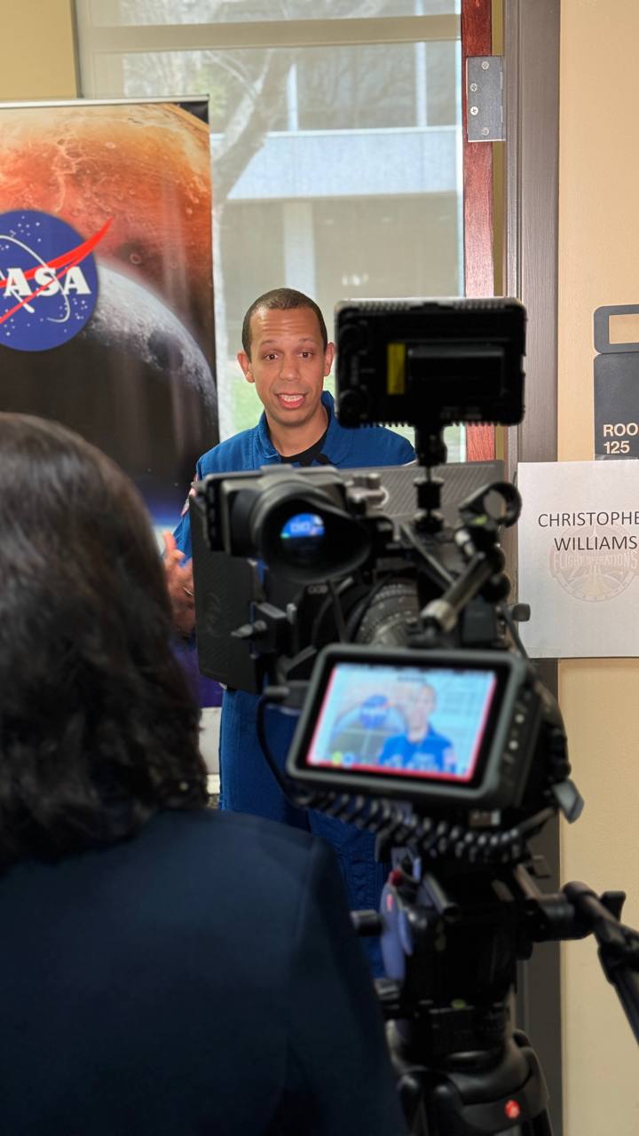 Daysi Marin entrevistando al astronauta Christopher Williams de la NASA con cámara profesional en el Johnson Space Center