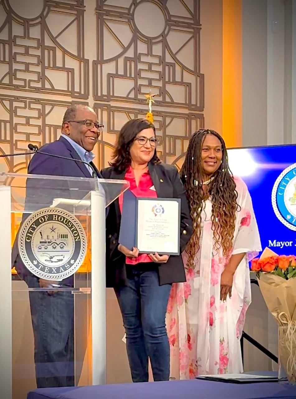 Daysi Marin recibiendo certificado en el podio del City of Houston junto a la Dra. Sonia White