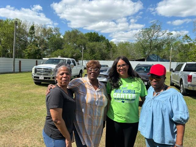 Rachelle Carter con simpatizantes de la comunidad usando camisa verde de campana