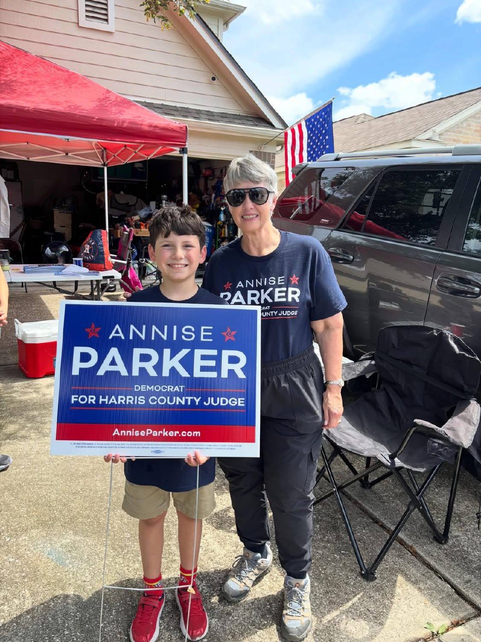 Annise Parker con joven simpatizante sosteniendo letrero de campaña en evento comunitario