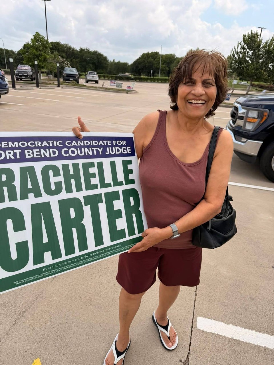 Simpatizante sonriente sosteniendo letrero de Rachelle Carter