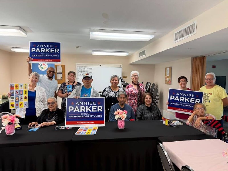 Annise Parker con adultos mayores de Nueva Vida sosteniendo carteles de campaña